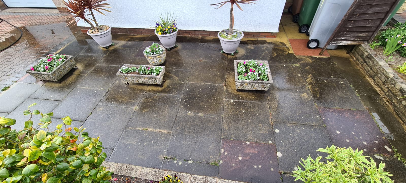 Dirty patio slabs and planters before jet washing in the Wirral