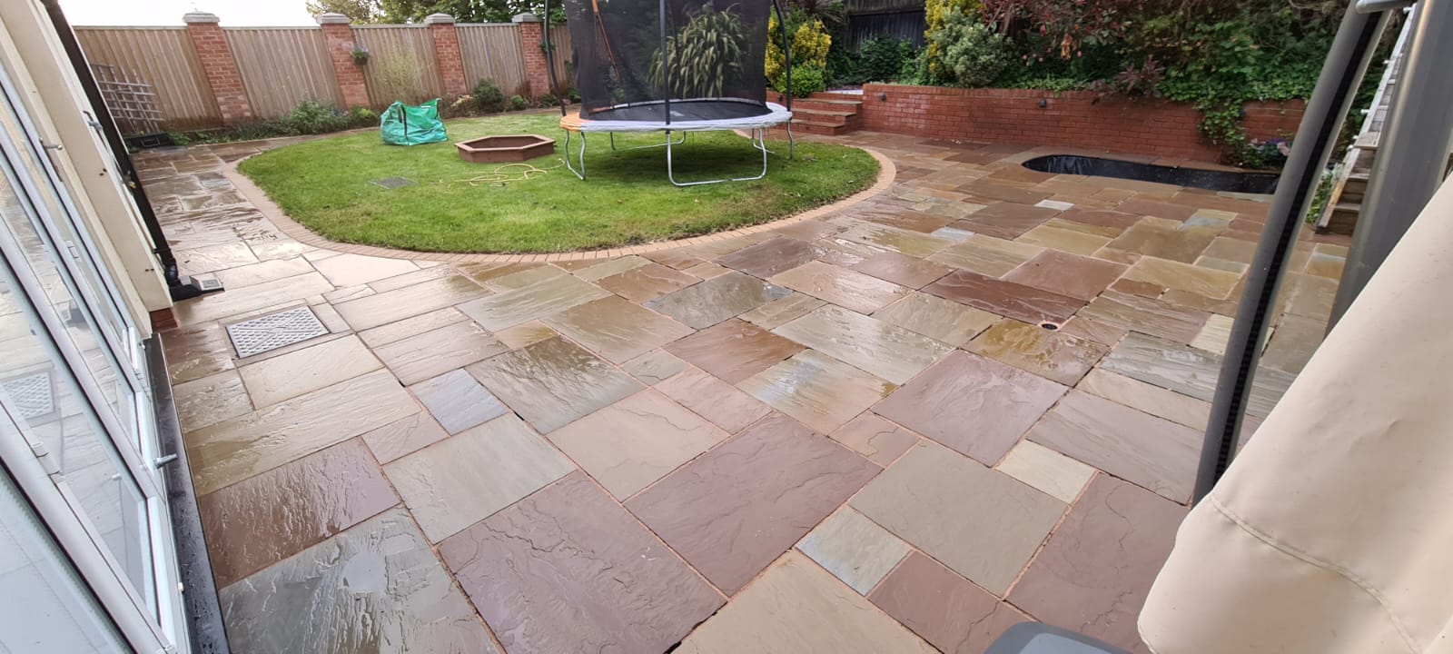 Pale square patio slabs jet washed at a Wirral property