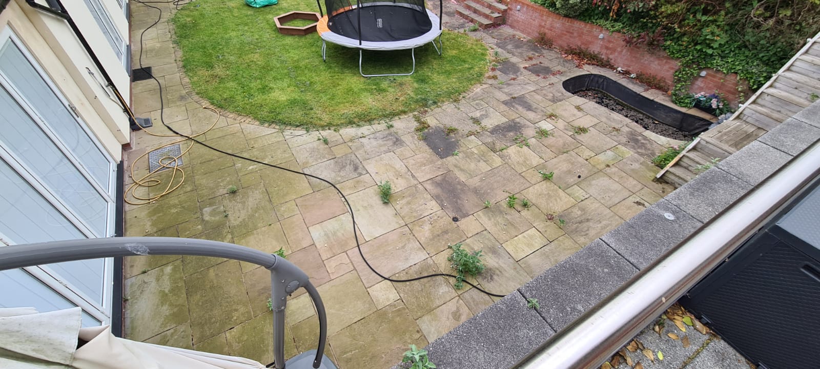 Algae covered garden patio before pressure washing in the Wirral