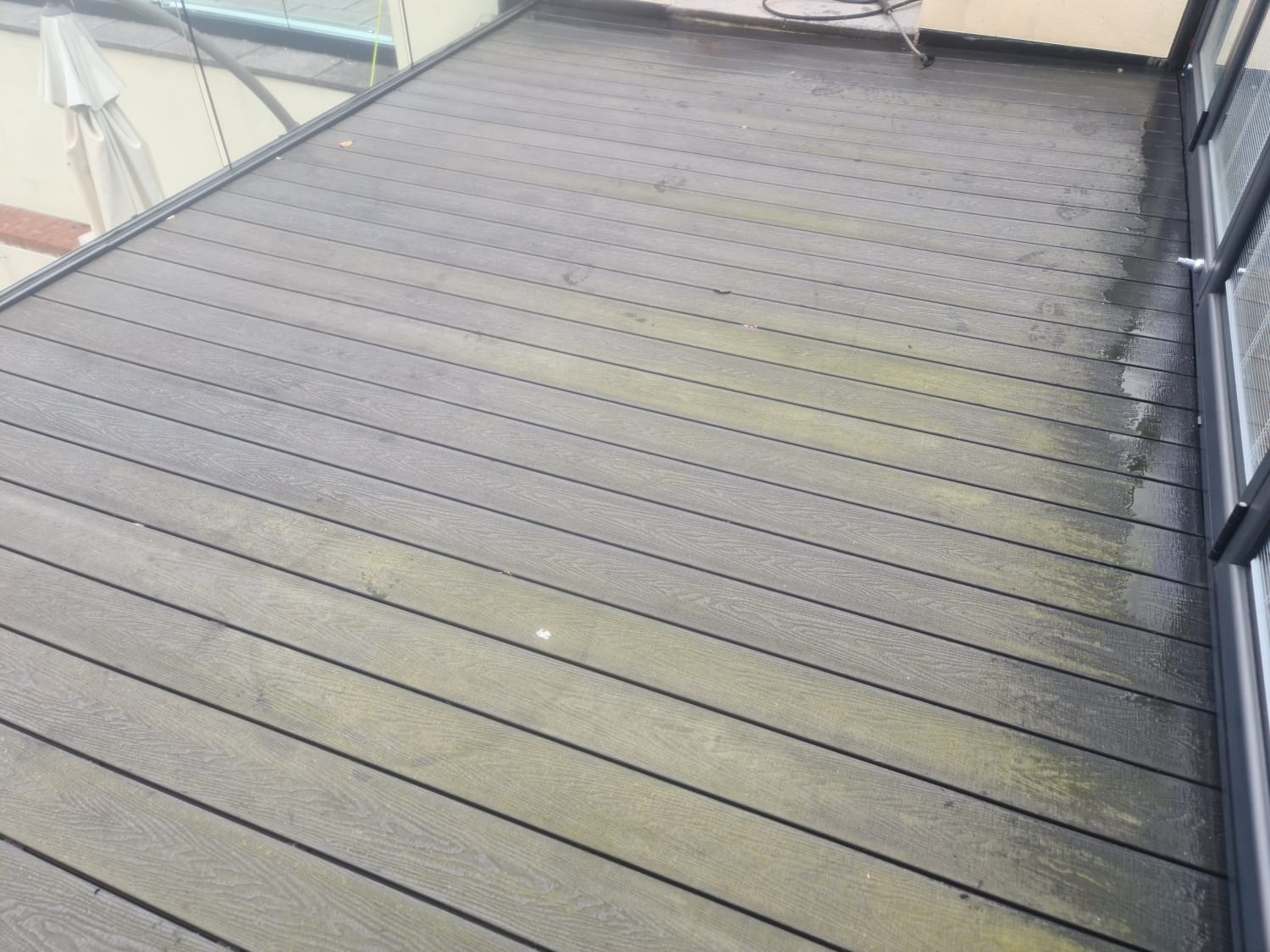Grey composite decking with grime before pressure washing in the Wirral