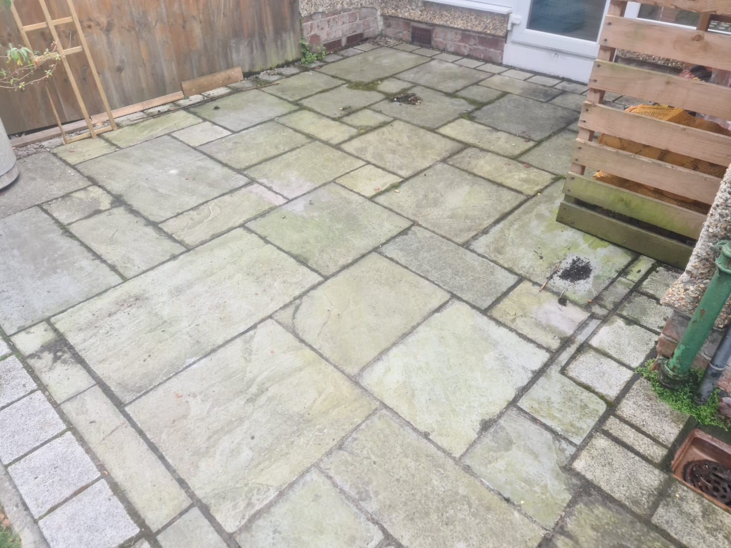 Dirty Indian sandstone patio before cleaning in the Wirral