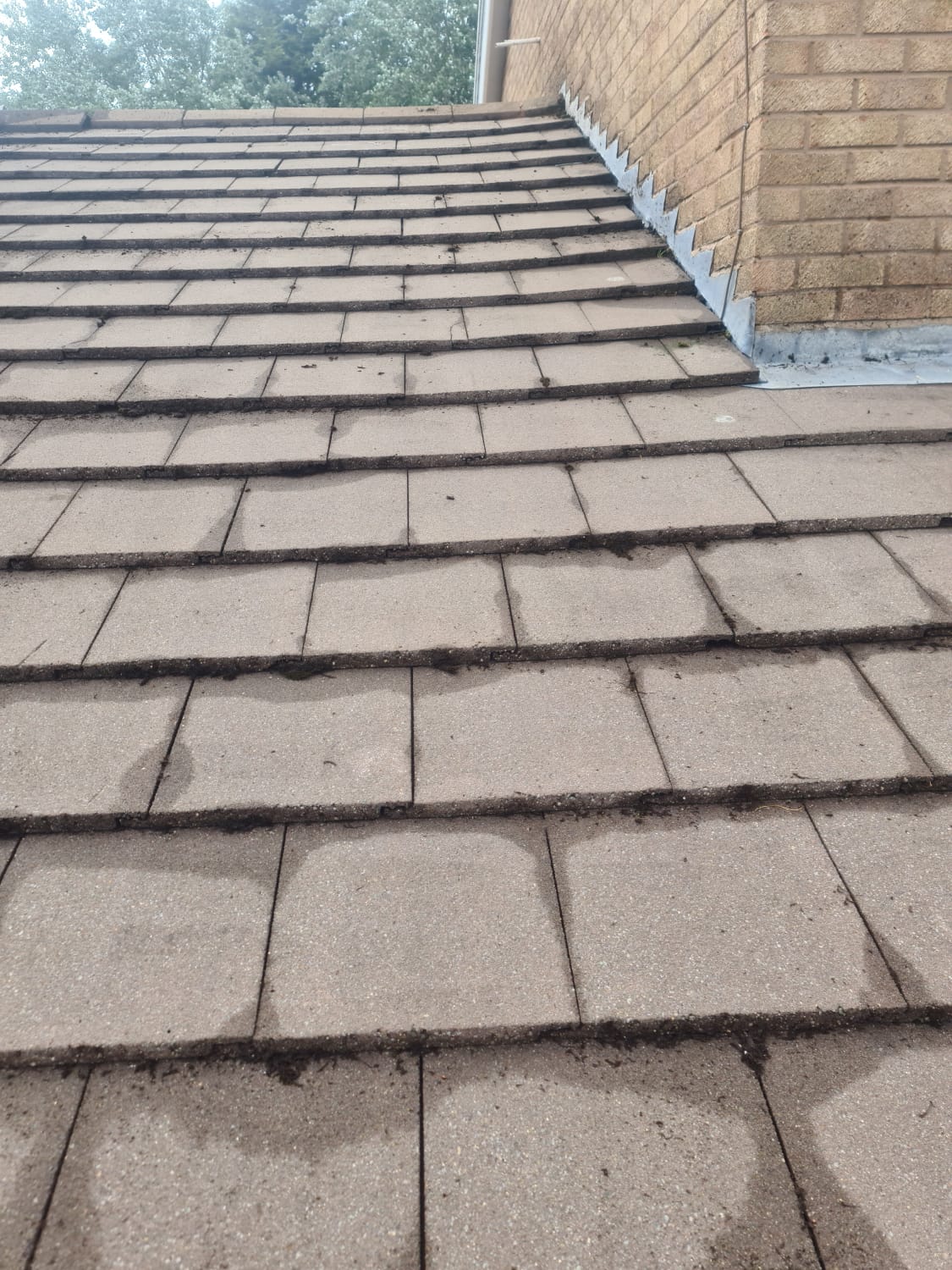 Roof cleaning brush removing moss from tiles in the Wirral