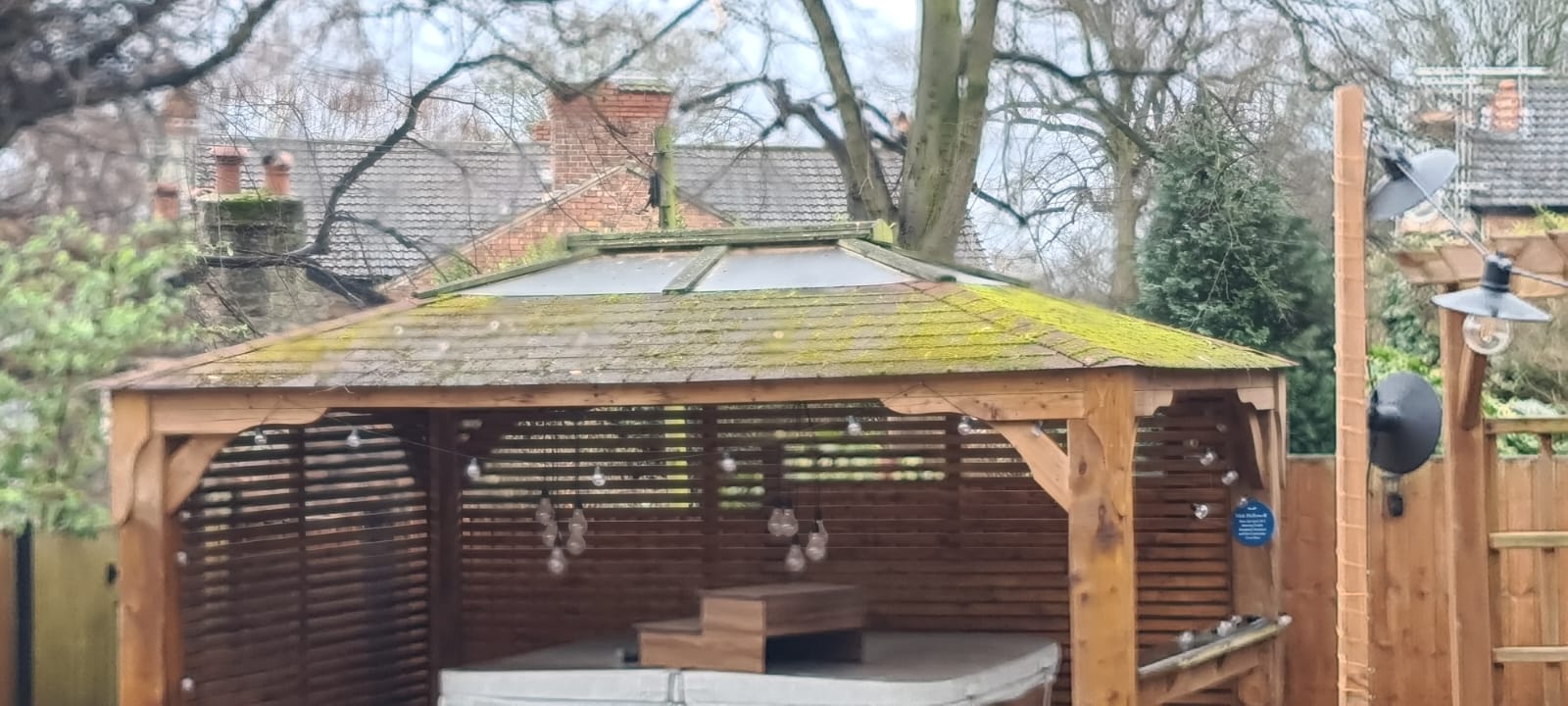 Dirty garden gazebo and hot tub surround before cleaning in the Wirral