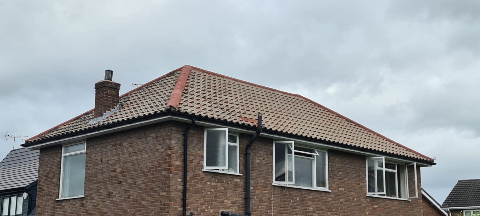 Fascia and soffit cleaning in the Wirral, cleaned white fascias and black guttering on a brick bungalow