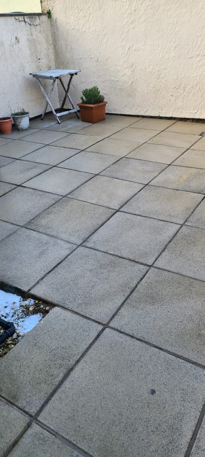 Brick paving cleaned beside a low garden wall in the Wirral