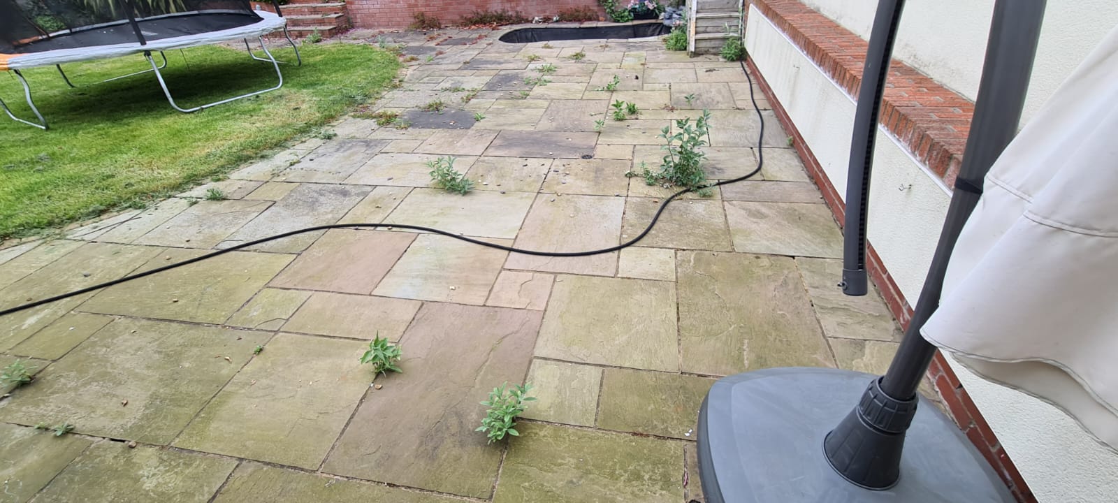 Soiled sandstone patio before a Wirral patio clean