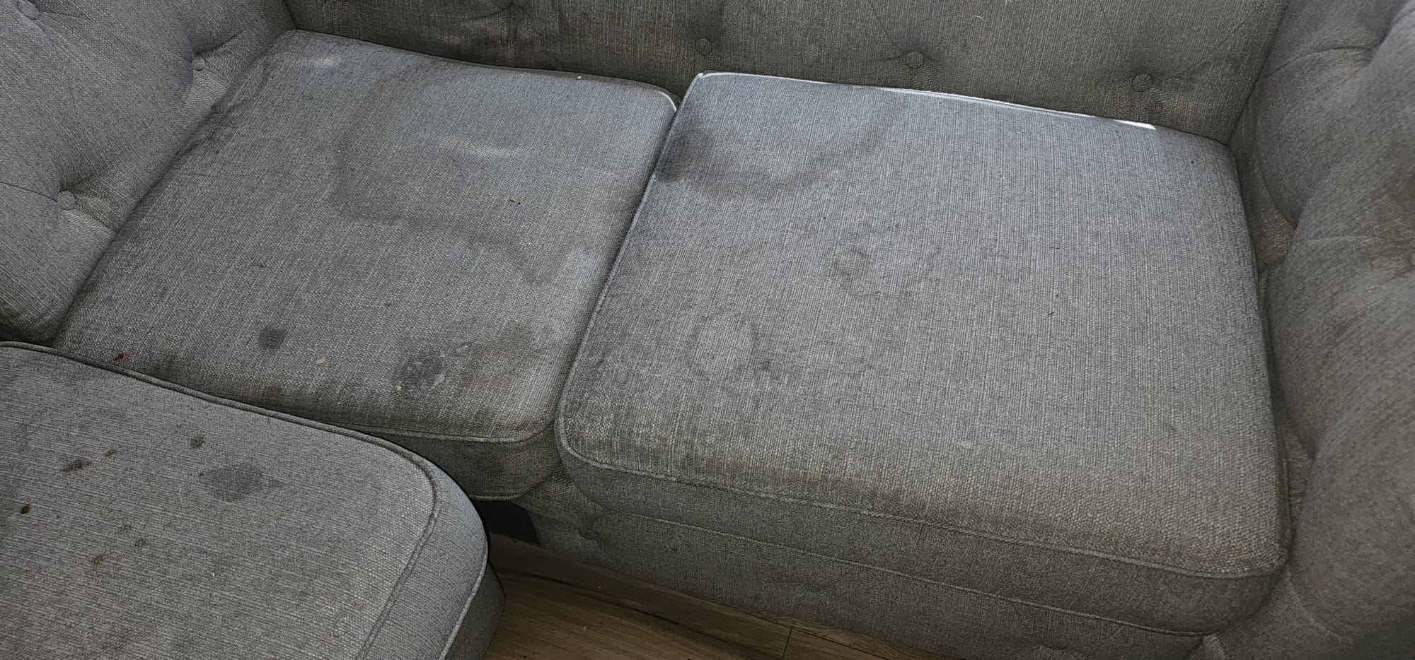 Stained grey sofa cushions before upholstery cleaning in the Wirral